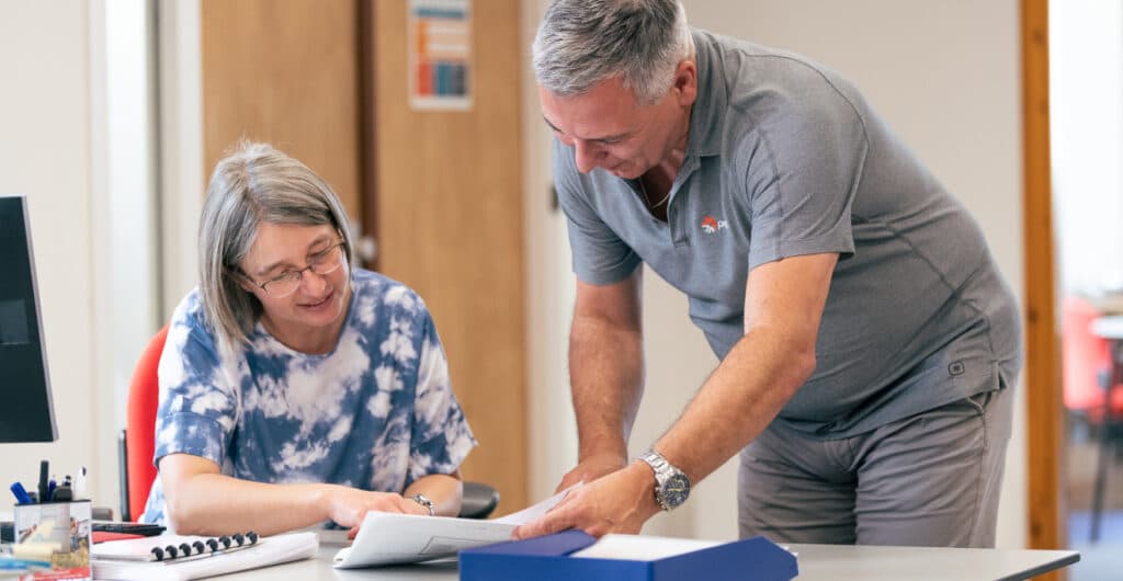 Two employees look at plans