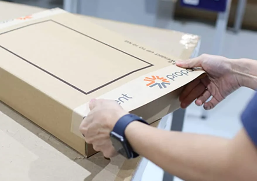 Employee sticks Proponent branded tape to a package for shipping