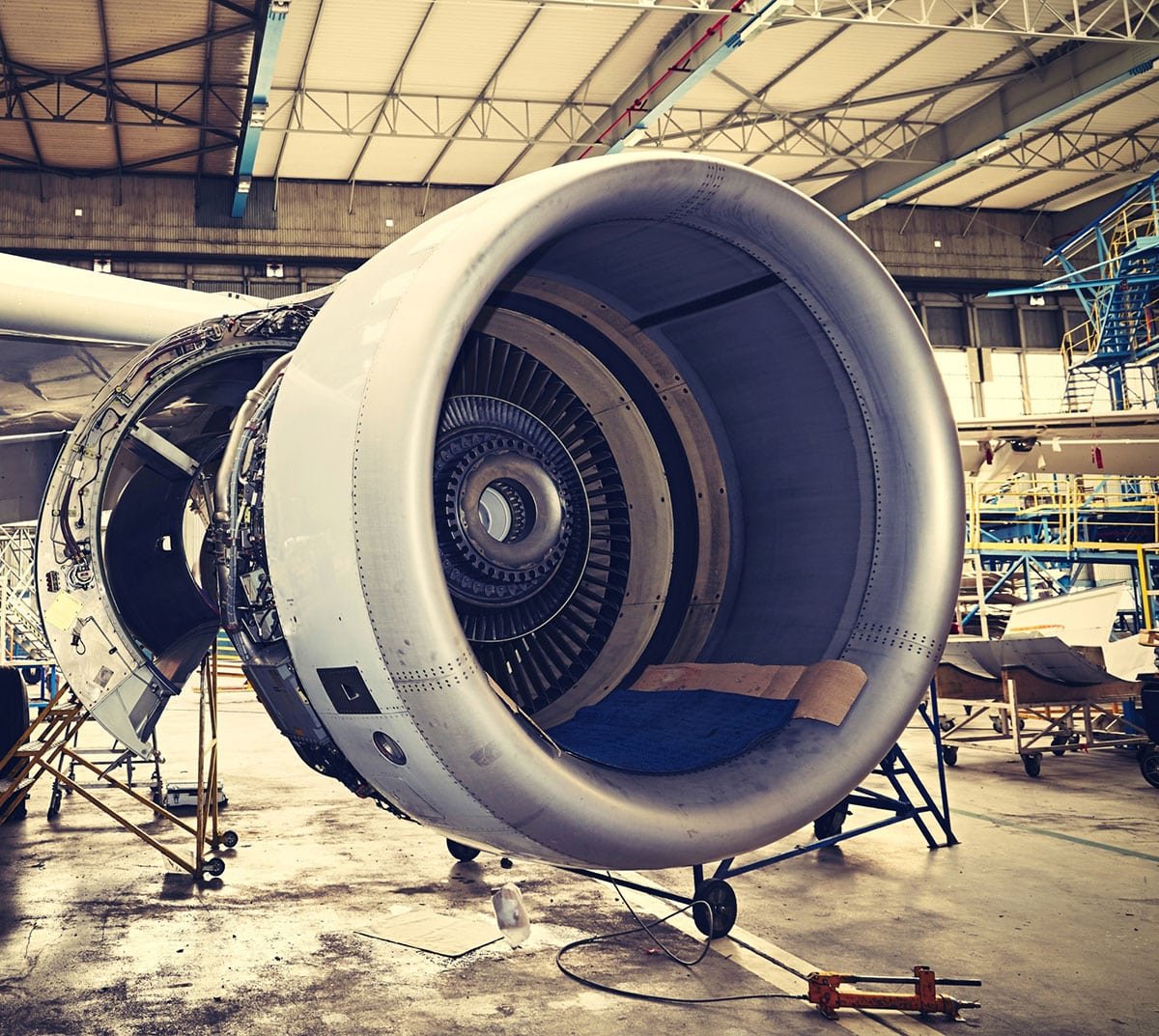 A partially disassembled jet engine in a hangar