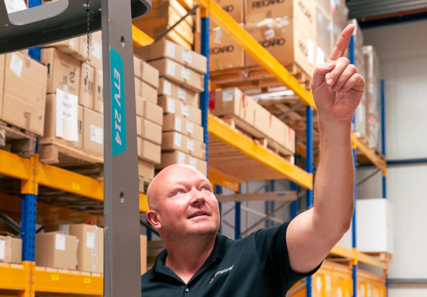 A man points up to something in a warehouse