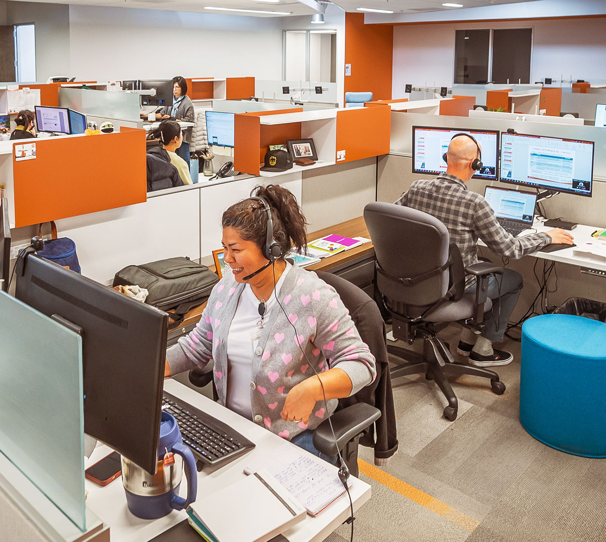 Wide shot of a team of people, wearing headsets.