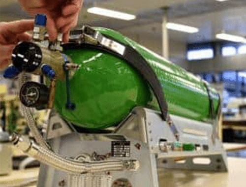 Green oxygen tank, with valves being adjusted by an employee
