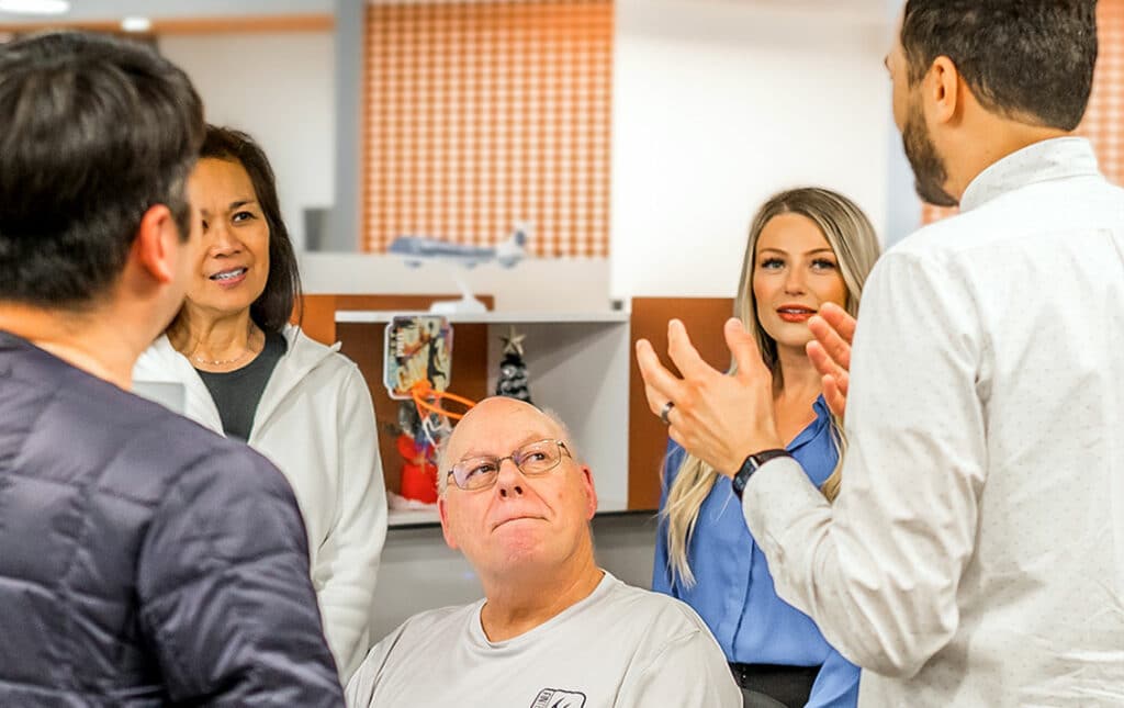 A team of people are listening to a man talk