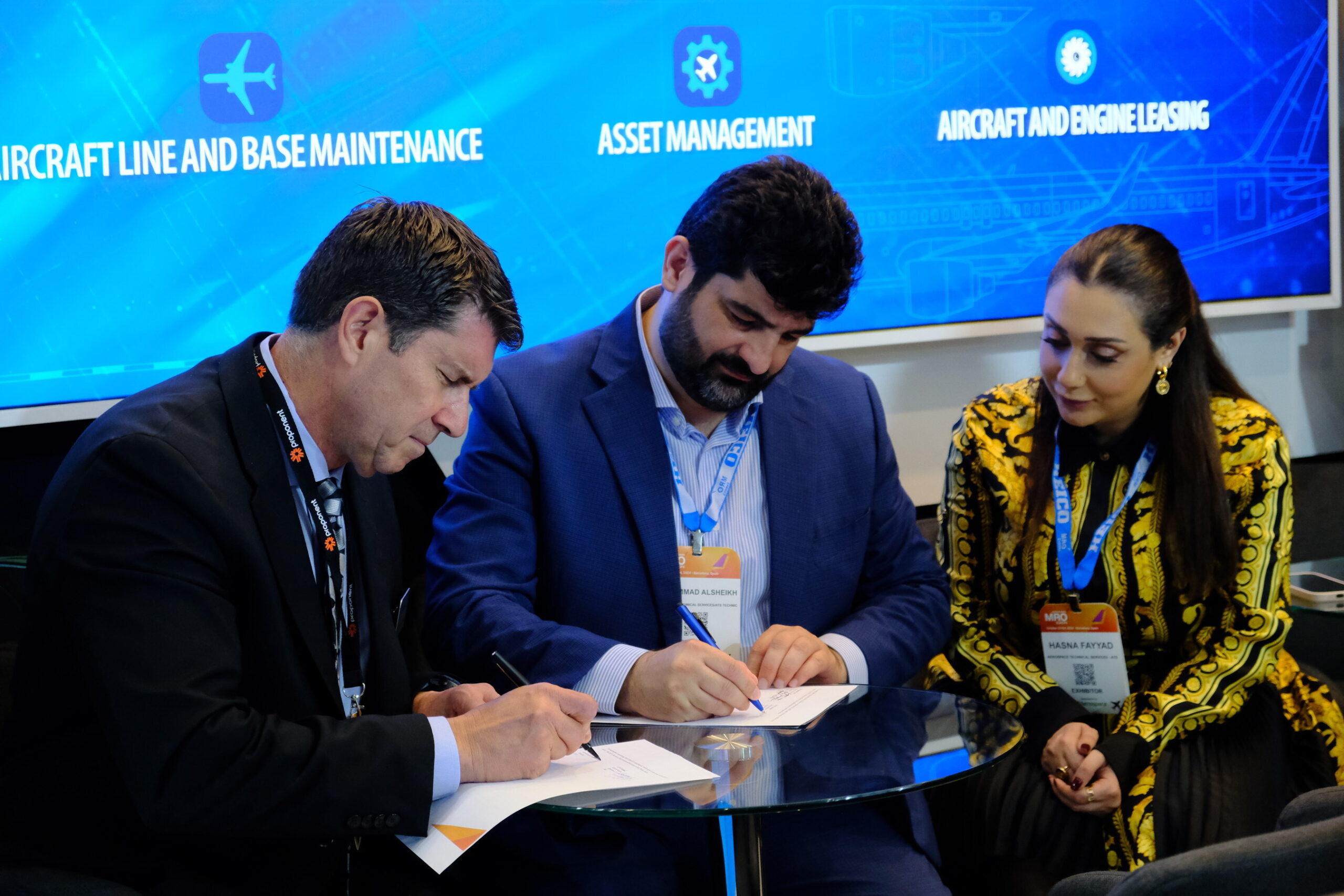 Three people reviewing and signing documents